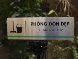 Phối cảnh bảng tên phòng dọn dẹp inox 304 đặt trên tripod – Bảng Hiệu Vàng Phối cảnh thực tế bảng tên phòng dọn dẹp inox 304 brushed đặt trên tripod ngoài trời